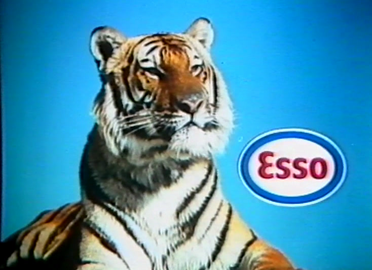 Against blue, a tiger lies beside the red and blue Esso oval.