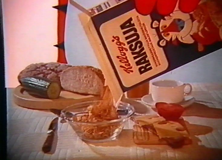 A breakfast table with bread and butter, a Kellogg’s Raksuja box tipped to camera.