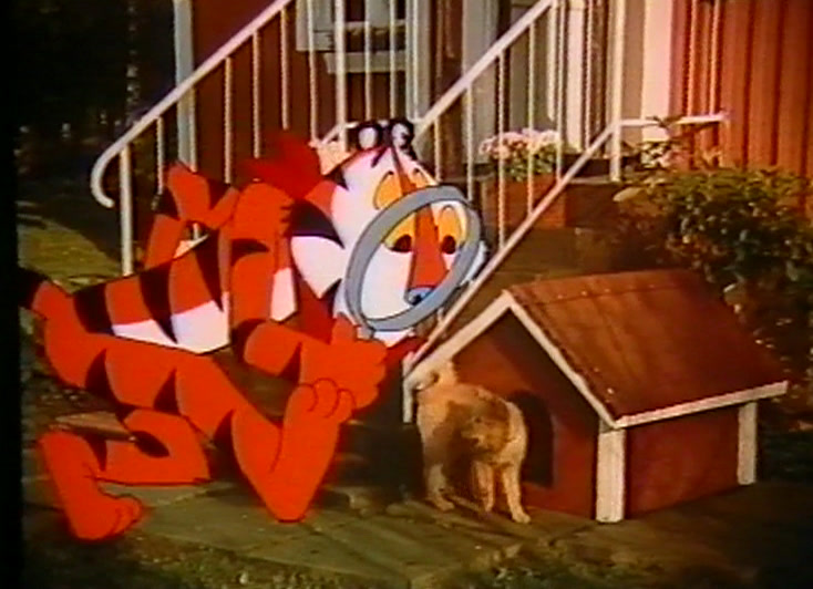 Tony the Tiger, drawn, holds a magnifying glass by a kennel; a real dog watches.