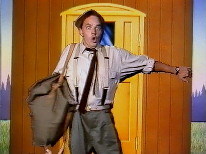 A man in shirt and braces flings his arms wide in a yellow doorway.
