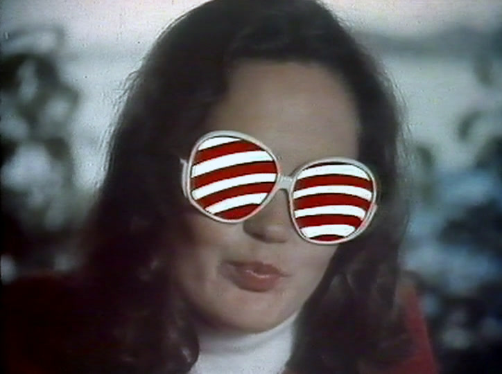 Her sunglass lenses have turned into red and white candy stripes as she speaks.