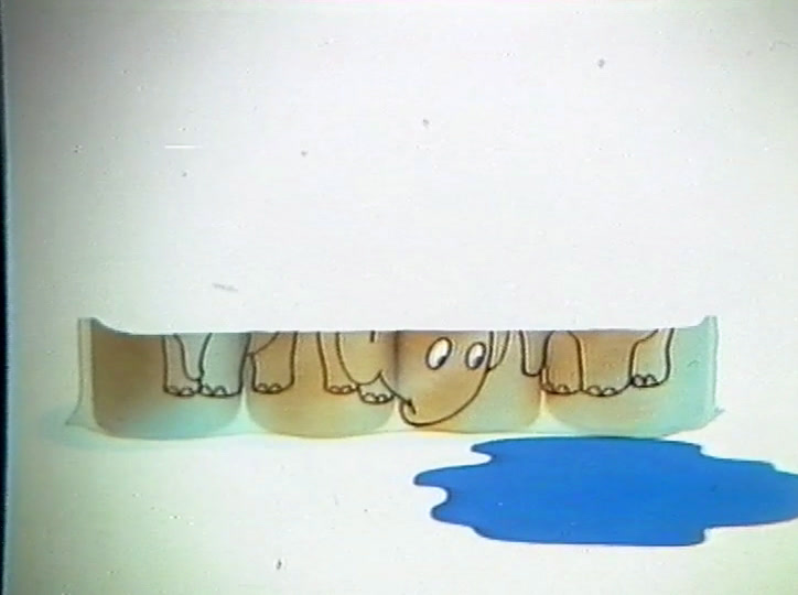 A four-roll pack printed with elephants stands beside a blue puddle.