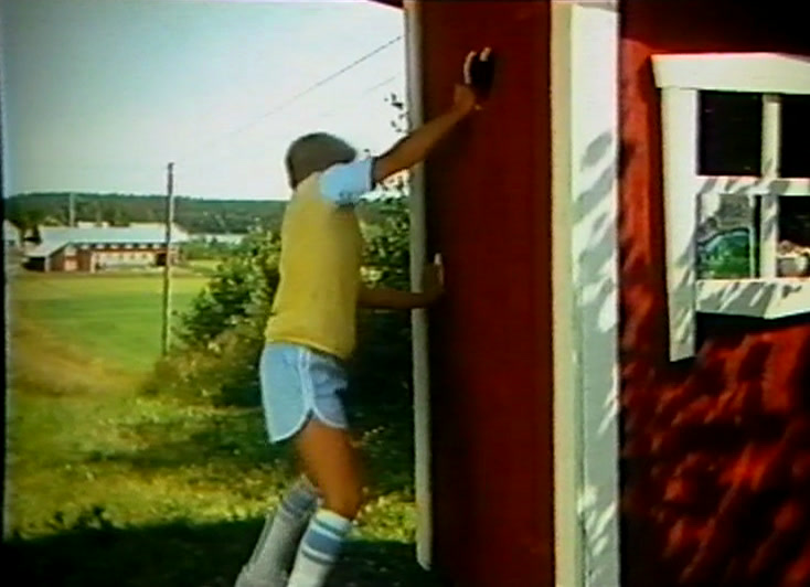 A girl in a yellow top runs along a track towards an open red door.