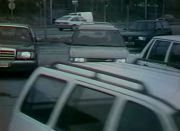 A jam of cars and estates fills a wide grey junction.