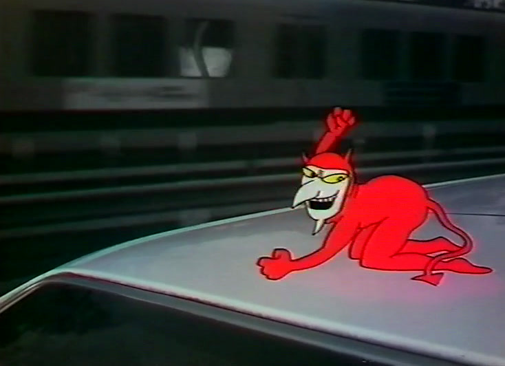 The red devil sprawls across a car roof with a train carriage passing behind.