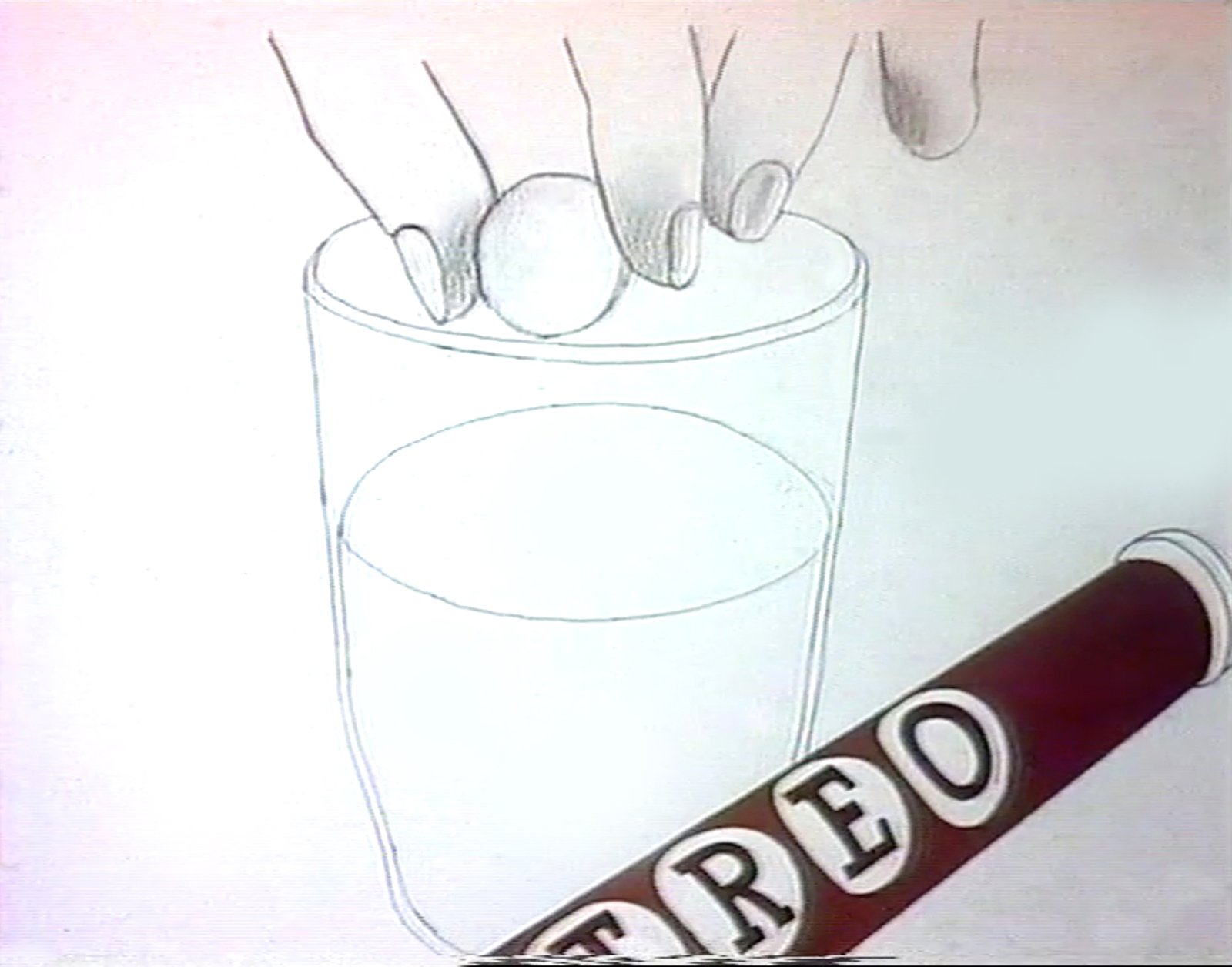 Still from Treo, fingers hold a round tablet above a glass of water beside a brown TREO tube