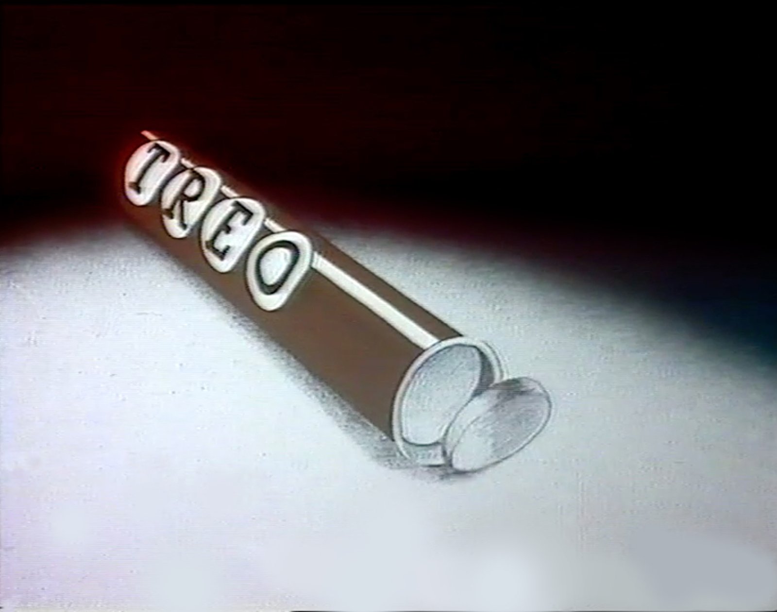 Still from Treo, an open brown TREO tube lies diagonally beside loose round tablets