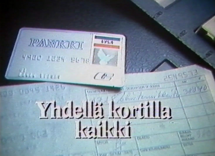 A bank card lies on printed slips with a subtitle across the bottom.