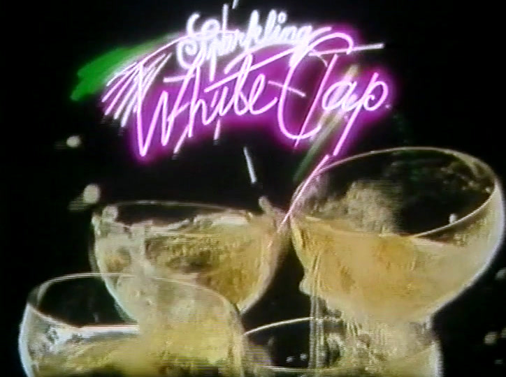 The neon script Sparkling White Cap glows above two full glasses.