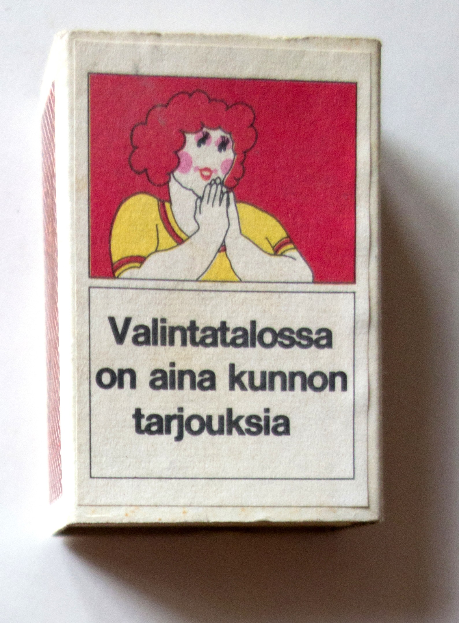 A Valintatalo matchbox printed with the woman from Hyvä tyttö and the line Valintatalossa on aina kunnon tarjouksia.